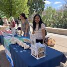 UC Davis Sustainability interns smile and talk to a student at the UC Davis Farmer's Market